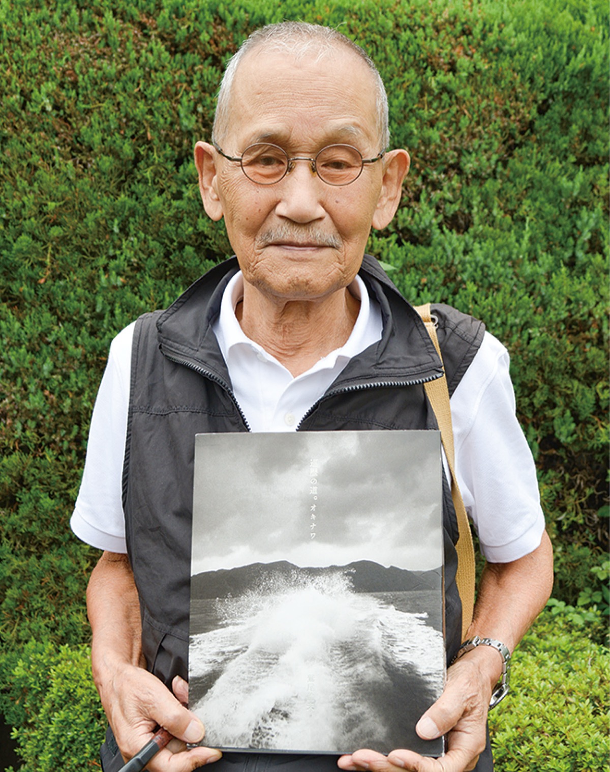 写真集を手に微笑む鷲尾さん