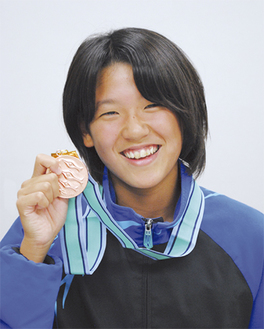 「２月の日本選手権でベストを」とメダルを手に話す小堀さん