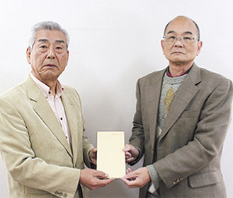 小野沢事務局長（左）から手渡される今井会長