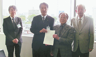 ▲提言書を手渡す石井部会長（右から２番目）と田中勝年副部会長（右）