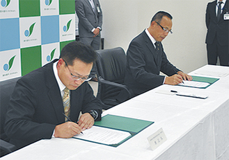 協定書にサインする原理事長（左）と加山市長