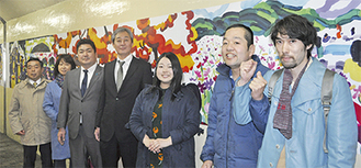 壁画を背にする町田さん（右から２番目）や同組合の会員