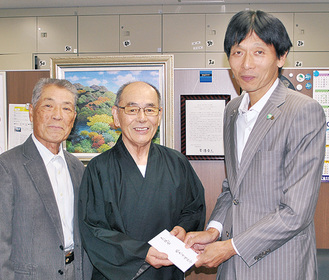 中島区長（右）に寄付する笹野責任総代（中央）と松浦総代