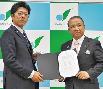 「ＳＤＧｓ協働推進宣言」の署名を交わす佐藤理事長(左)と本村市長