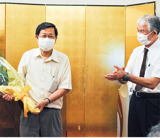 長年の労をねぎらい、花束を贈られた浦上理事長（左）