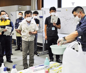 消毒液の作り方について学ぶ担当職員たち＝14日、消防指令センター
