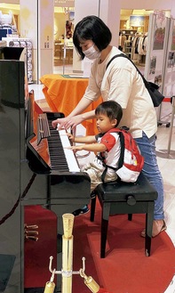 お母さんと一緒に鍵盤を弾く男児
