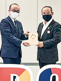 市役所で行われた「さがみはらSDGsパートナー登録証盾交付式」で本村賢太郎市長から盾を受け取る阿部公太郎社長（左）