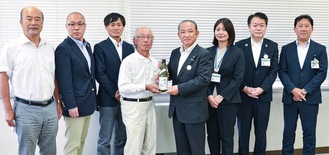 完成した純相模原産の日本酒を本村市長に手渡す石井会長（左から４人目）