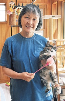 保護した猫を抱き微笑む山本さん