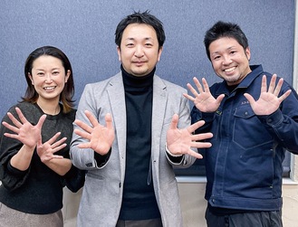 両手で満開の花火を表現する実行委員会の（右から）敦岡辰徳さん、安達さん、伊藤理恵さん