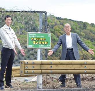 小倉地区（小倉橋付近）に設置されたガードレールを指さす佐藤組合長（右）と市の職員