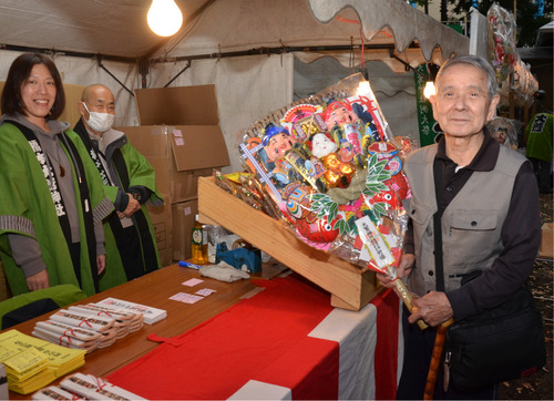 名物の縁起熊手を購入した来場者