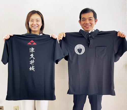 ポロシャツを手にする津久井商工会の職員。右が前面のデザイン、左が後面のデザイン