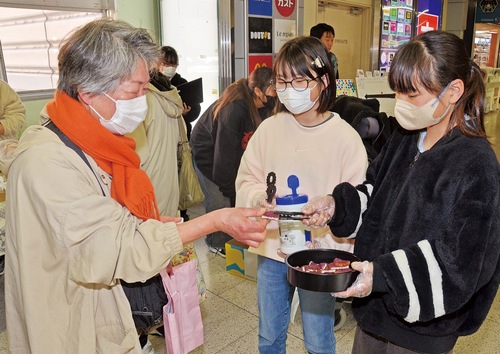 駅利用者に声を掛け、ラスクを渡す児童