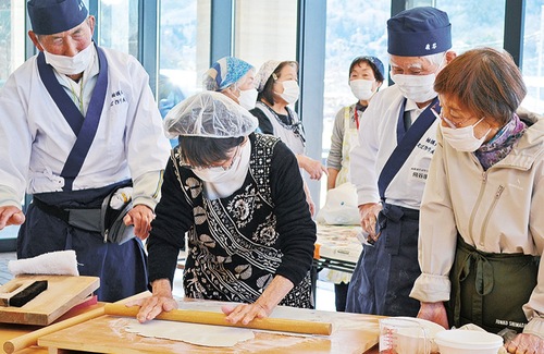 慣れない手つきでそばを練る参加者