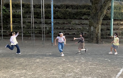 サングラスを掛けたハンターに捕まらないように逃げる児童