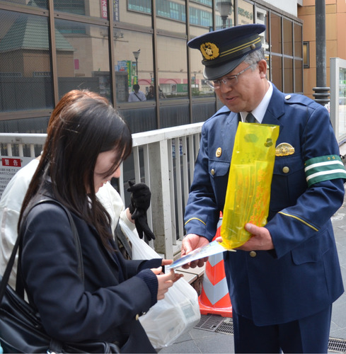 啓発物を手渡す山口署長