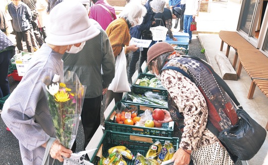 並べられた食品を選ぶ地域住民ら