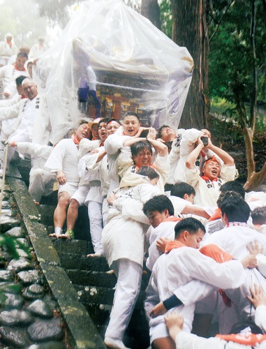 雨に濡れた急な50段の石段を威勢よく下る神輿