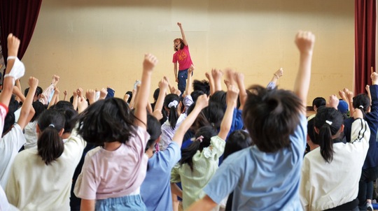 きよこさんのリードに合わせて元気よく拳を突き上げる児童