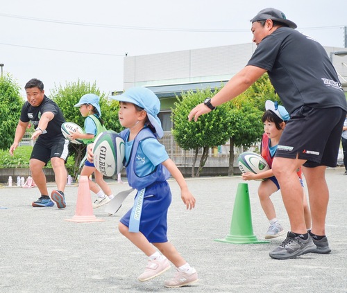 三菱重工相模原ダイナボアーズのスタッフに、腰のタグを取られないよう走る園児たち