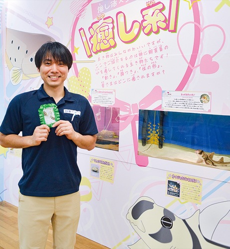 ｢推し｣の生き物の写真を手に笑顔の山田さん