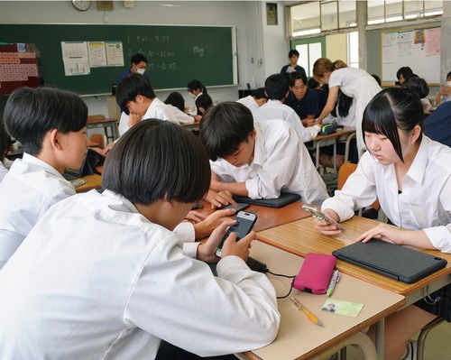 デジタル機器を使って情報収集する生徒たち