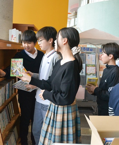 本棚に本を収める、ＬＣＡ国際小学校で図書委員を務める児童たち