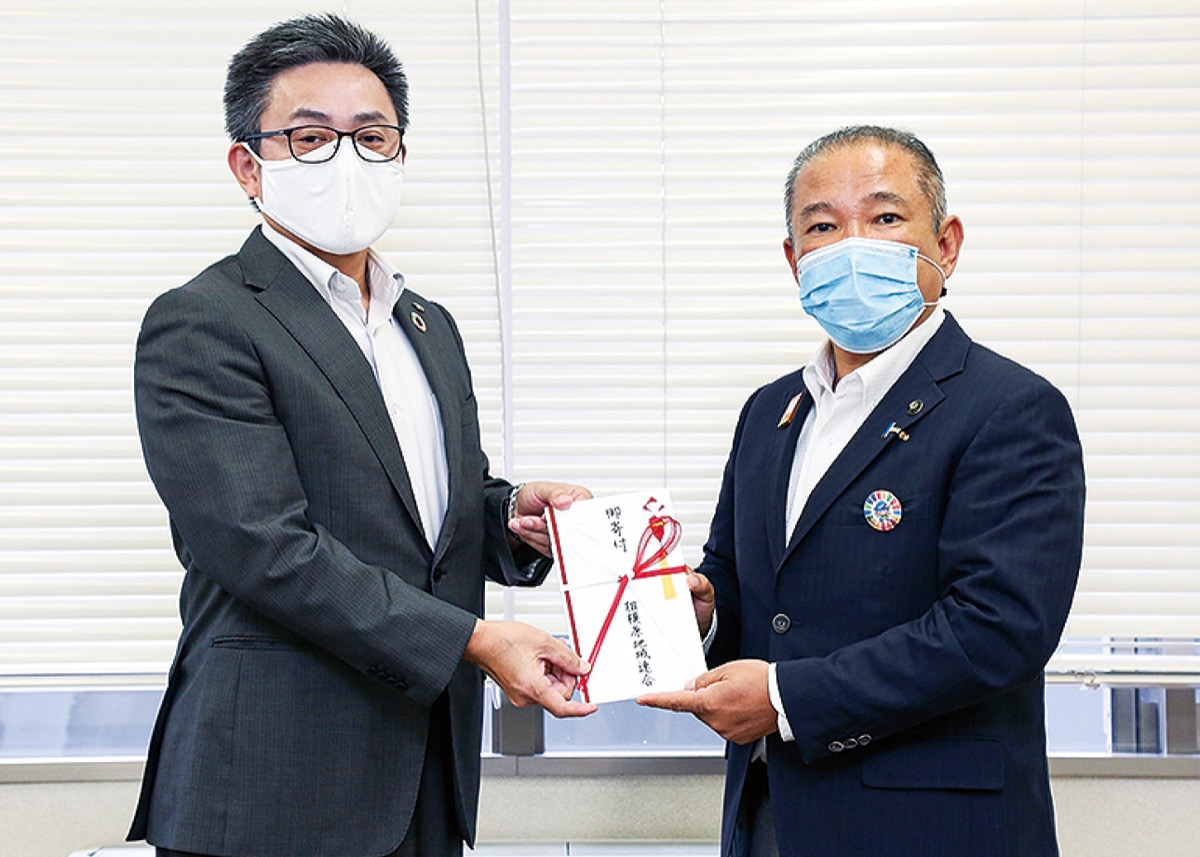 寄付金を手渡す川崎議長（左）と本村市長