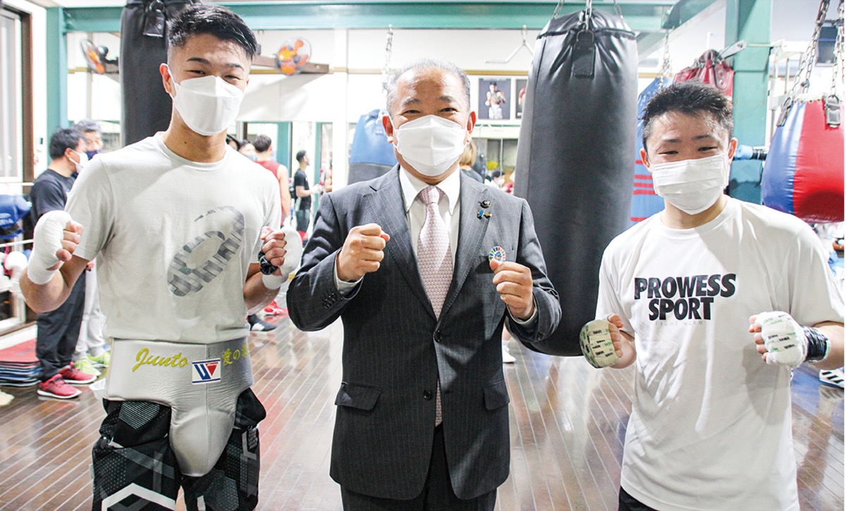 中谷選手（左）、石澤選手（右）の2人のチャンピオンとファイティングポーズで撮影に応じる本村市長＝2月4日、M.Tジム