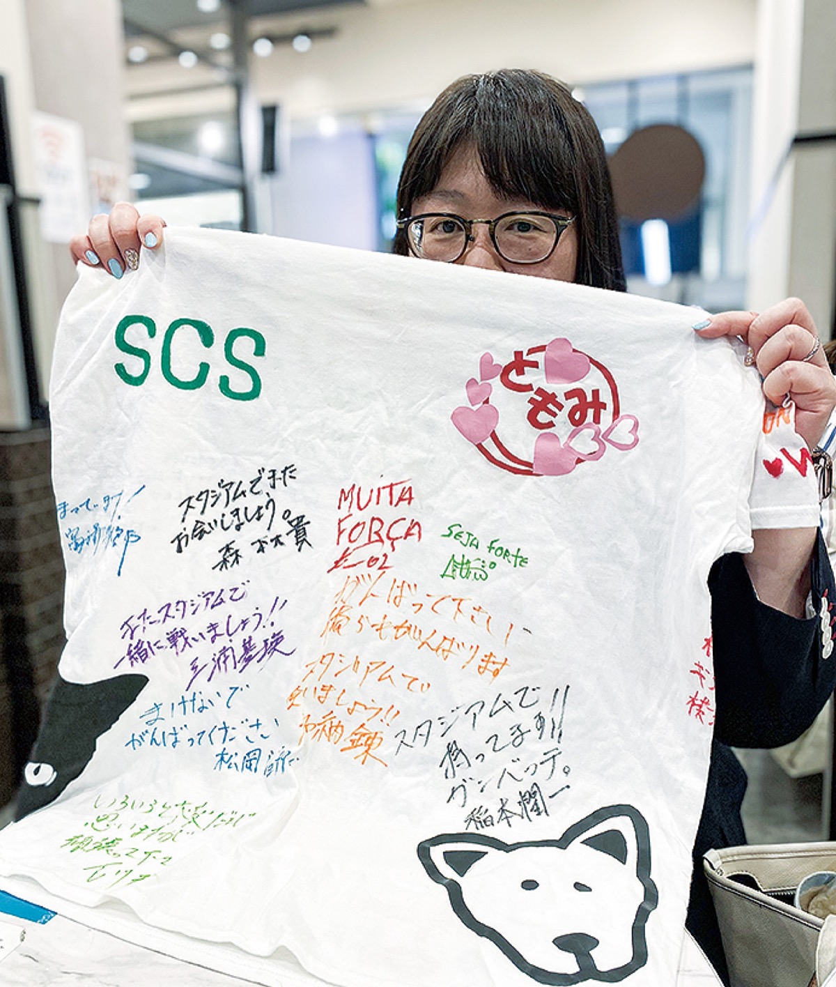 「宝物」という思い出のTシャツを持つ三樹さん