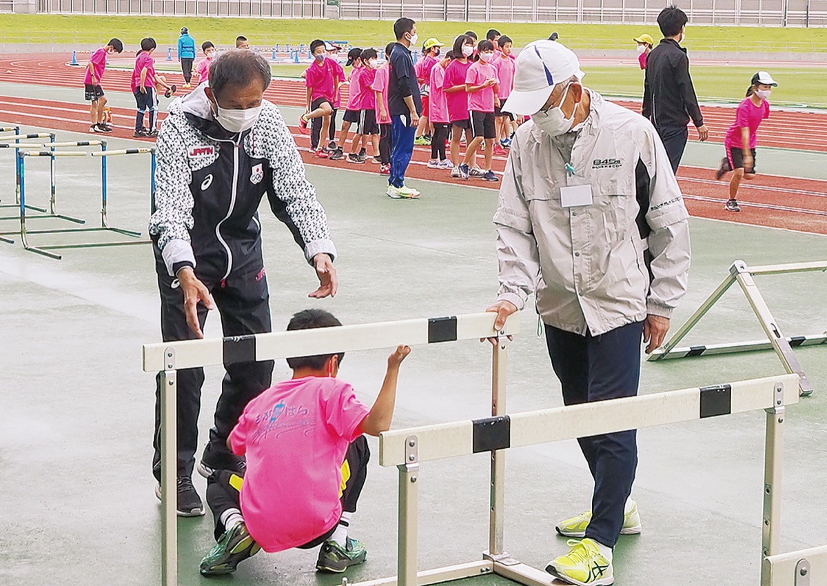 小学生を熱心に指導する神藤会長(左)