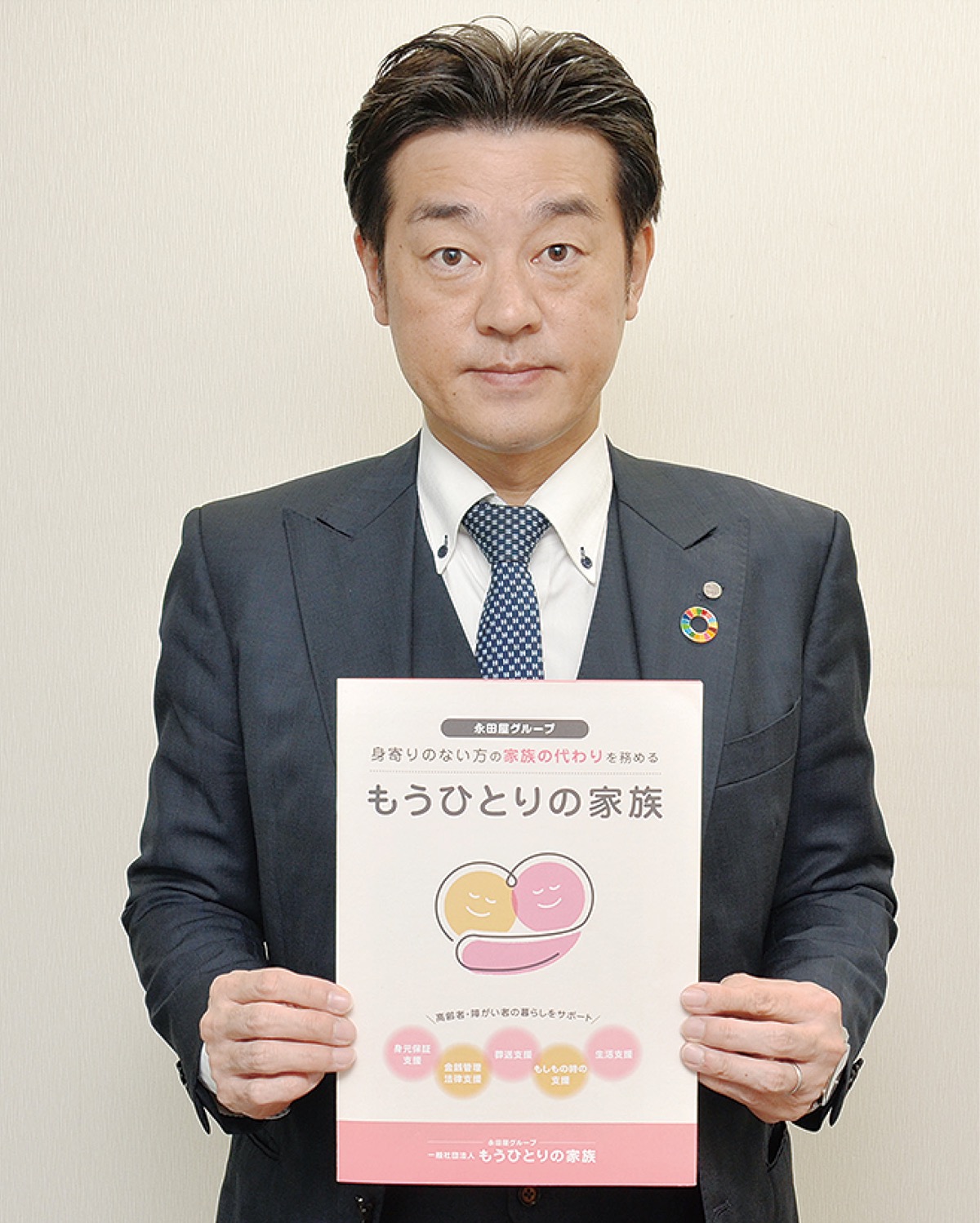 もうひとりの家族の冊子を手にする田中代表