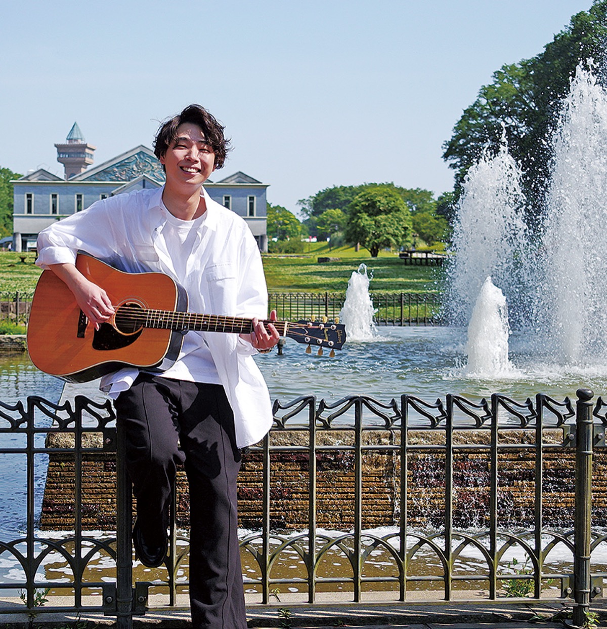 思い入れのある麻溝公園でギターを手にする小林さん