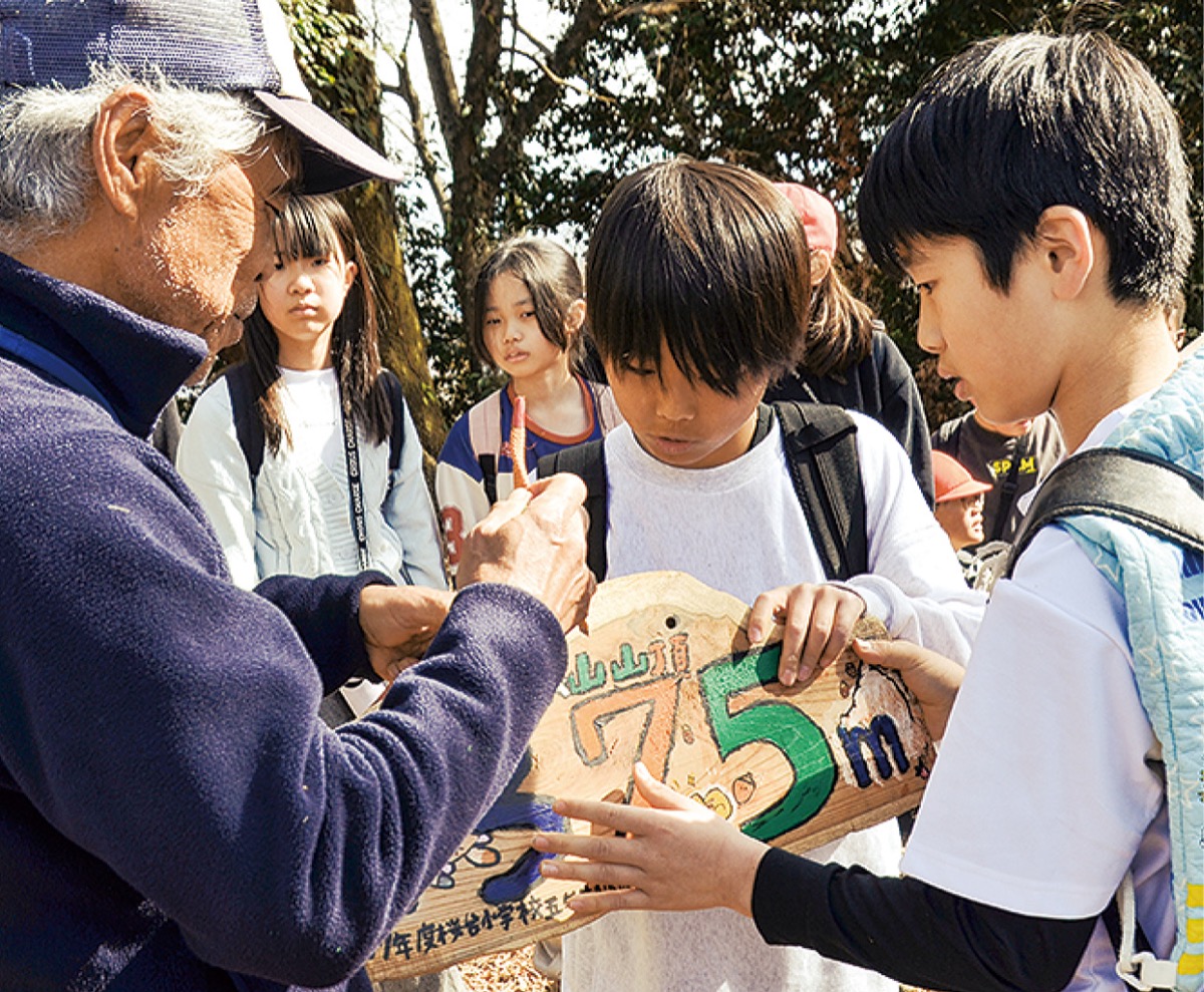 看板にひもを通す児童