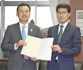 署名した協定書を手に上野孝典町田市議会議長（左）と阿部善博相模原市議会議長