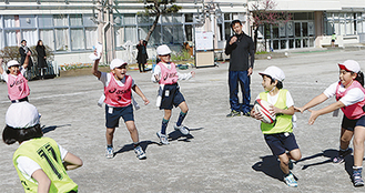 ボールを持って走り回る児童と小野澤宏時さん＝２月21日・町田第二小