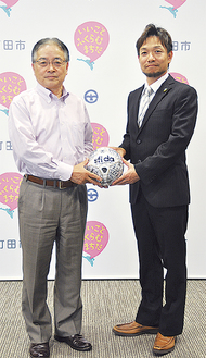 石阪丈一町田市長（左）にボールを手渡す甲斐修侍さん