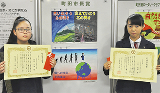 受賞作品を前に表彰状を掲げる蛭田七海さん（左）と小川翔和さん