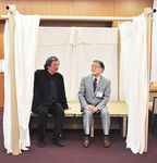 簡易間仕切りシステムの居心地を確かめる坂氏と石阪市長