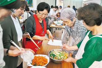 料理指導する尹先生（左から２人目）