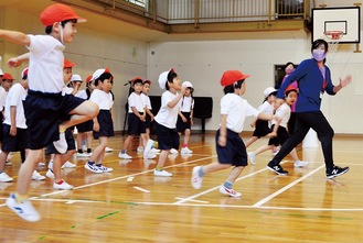 関根さん（右）にオリンピック選手のトレーニングを教わる児童ら
