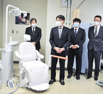 歯科ユニットを説明する長崎会長(左から２人目)と役員の皆さん