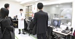 研究用MRIの説明を受ける見学者