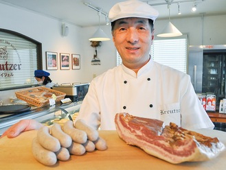 発酵無添加ソーセージとベーコンを紹介する店主の吉岡さん