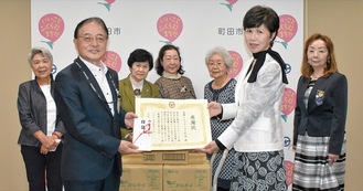 石阪市長から感謝状を受け取る柴崎会長（中央右）とメンバーら（後列）
