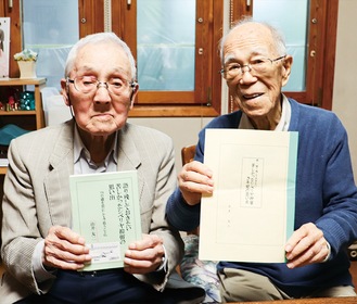 著書を手にする由井さん（左）と後輩の籔本さん