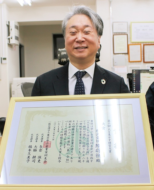 賞状を前に笑顔をみせる安藤さん