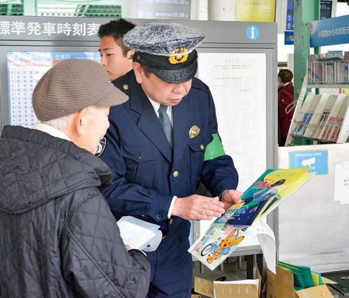 女性に啓発物について説明する署員